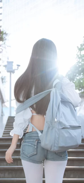 阳光下的青春背影，白色露背上衣与牛仔短裤的夏日街拍